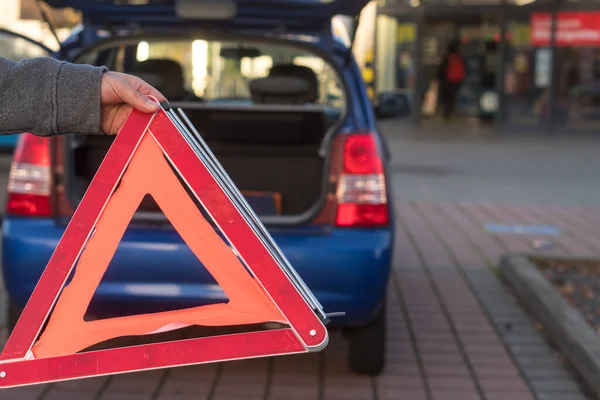 红色三角形警告标志和抛锚的汽车在远处 — 图库照片