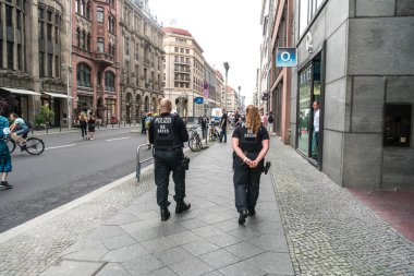 Berlin, Almanya - 13 Haziran 2020: Geri dönen polis ve kadın polis açık hava gösterisi sırasında elleri arkada rahatça yürüyor
