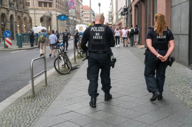 Berlin, Almanya - 13 Haziran 2020: Geri dönen polis ve kadın polis açık hava gösterisi sırasında elleri arkada rahatça yürüyor