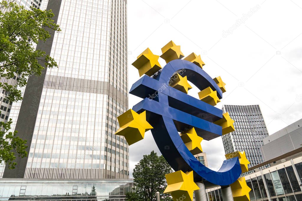 Frankfurt am Main, Germany - June 28, 2020: The Euro-Skulptur (German for Euro sculpture) set up in front of the European Central Bank, electronic signage showing a Euro sign and twelve stars around