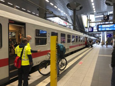 Berlin, Almanya - 9 Temmuz 2020: Deutsche Bahn 'ın Şehirlerarası Treni ve tıbbi maske takan çalışanlar ve yolcular