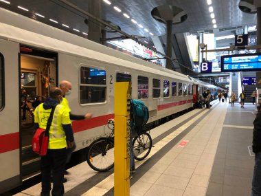 Berlin, Almanya - 9 Temmuz 2020: Deutsche Bahn 'ın Şehirlerarası Treni ve tıbbi maske takan çalışanlar ve yolcular