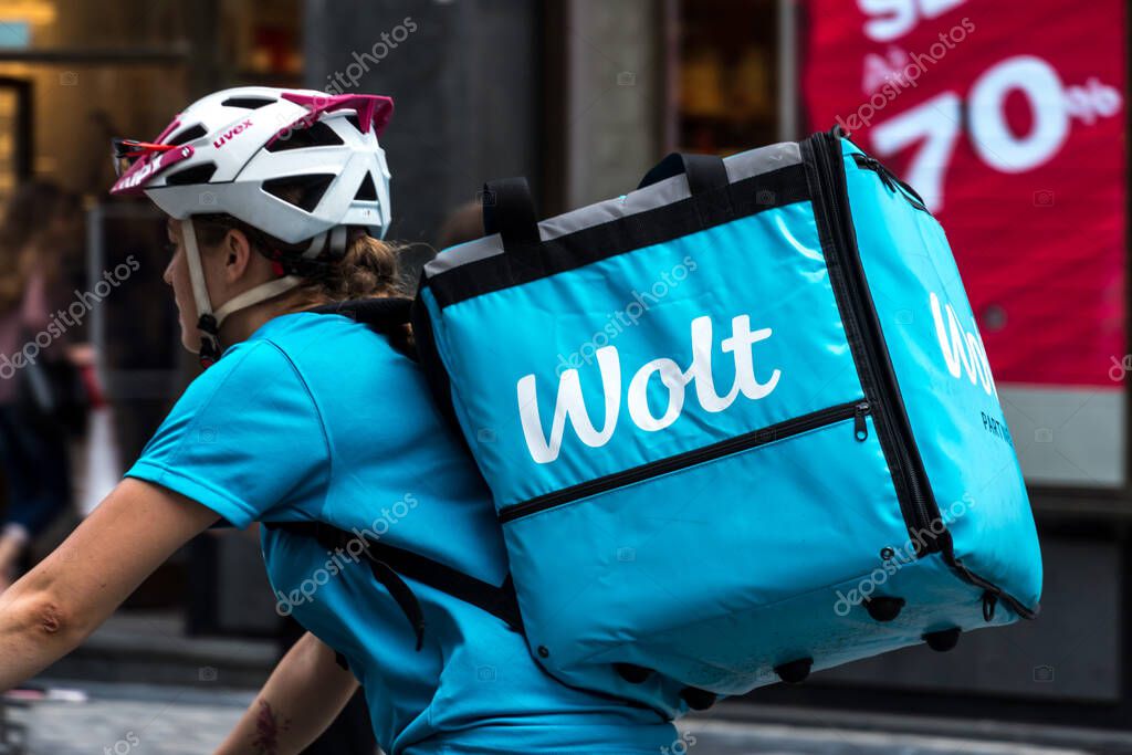 Prague, Czech Republic - July 23, 2020: Wolt delivery guy at work on bike. Wolt is a Finnish technology company known for its food-delivery platform