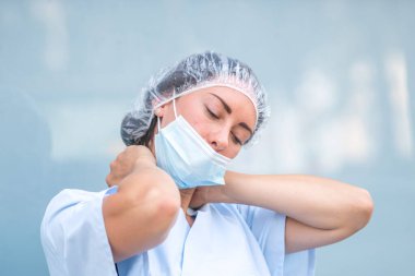Boyun kası zorlanması. Ağrılı boynuna masaj yapan yorgun ve acı çeken bir doktorun portresi.