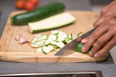 Erkek eli, sağlıklı bir yemek için taze kabak doğruyor ve doğruyor.