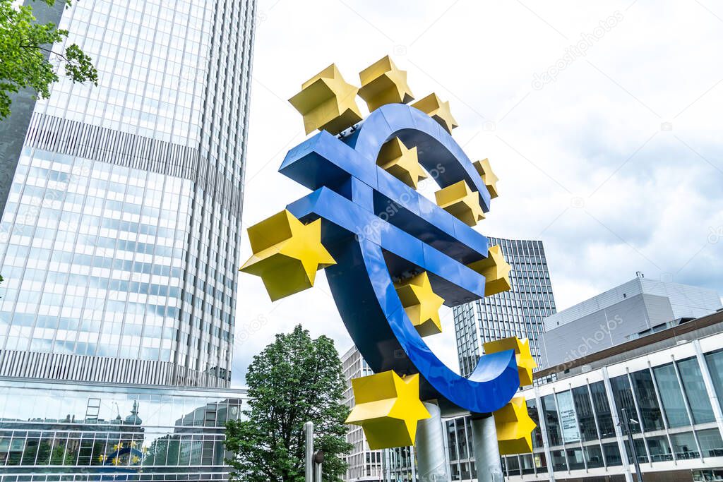 Frankfurt am Main, Germany - June 28, 2020: The Euro-Skulptur (German for Euro sculpture) set up in front of the European Central Bank, electronic signage showing a Euro sign and twelve stars around