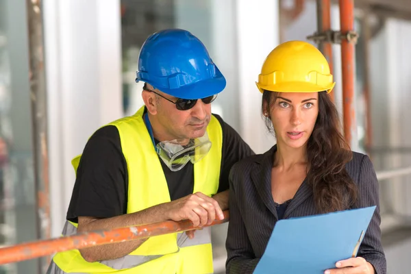 Nşaat Alanındaki Erkek Kadın Mühendisler Planlarını Ofis Planlarını Inceliyor — Stok fotoğraf