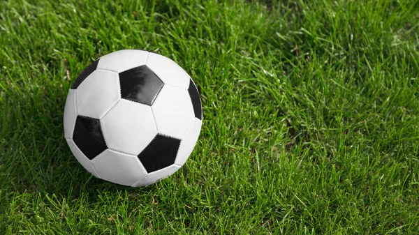 Fútbol o pelota de fútbol en el campo de fútbol. Espacio para texto en el lado derecho de la imagen —  Fotos de Stock