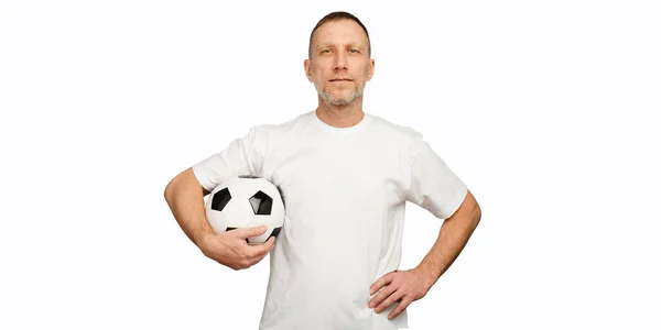 Bir adam akimbo pozunda bir futbol topu tutuyor. Oyuncu beyaz arkaplanda izole edildi