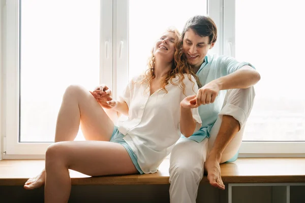 Menina feliz e homem abraçando perto da janela em casa . — Fotografia de Stock