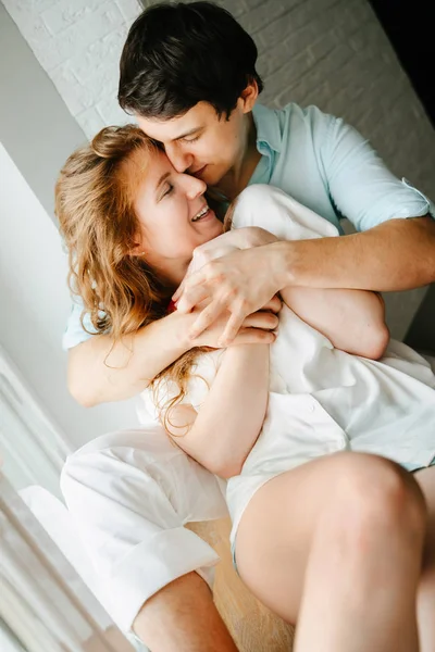 Menina feliz e homem beijando perto da janela em casa . — Fotografia de Stock