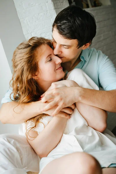 Chica feliz y el hombre abrazando cerca de la ventana en casa . — Foto de Stock