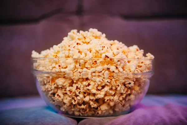 Hot popcorn in a bowl on the couch.