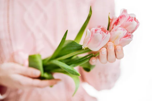 Mujer joven sosteniendo tulipanes rosados sobre un fondo blanco . — Foto de Stock