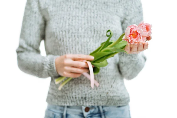 Mujer joven sosteniendo tulipanes rosados sobre un fondo blanco . — Foto de Stock