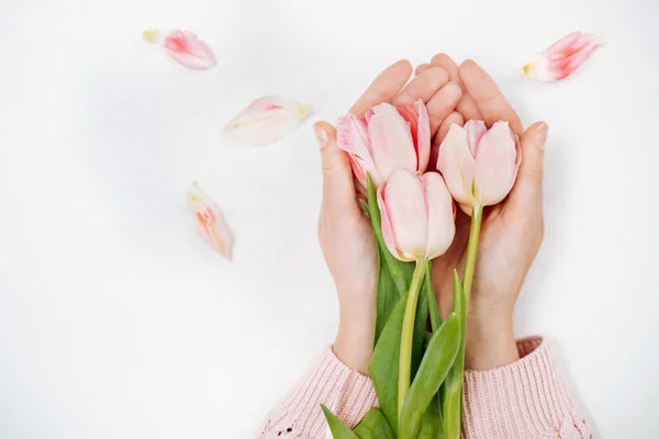 Chica joven sosteniendo un ramo de tulipanes rosados. Vista superior, fondo blanco . — Foto de Stock