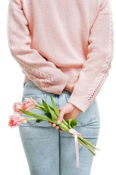 年轻的女人拿着粉红色的郁金香在她的背后在一个白色的背景. — 图库照片