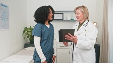 İki farklı sağlık uzmanı, bir doktor ve bir hemşire başarılı bir tıbbi danışma sırasında beşlik çakıyor. Modern bir klinik ortamında takım çalışması ve başarı göstererek olumlu haberi kutluyorlar..