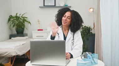 Çeşitli bir kadın doktor sanal bir tıbbi konsültasyon için çevrimiçi video aracılığıyla hastalarla bağlantı kuruyor. Kliniğinde modern teletıp ve dijital sağlık çözümlerini kucaklayarak profesyonel sağlık hizmetleri ve uzman tavsiyeleri sunmaktadır..