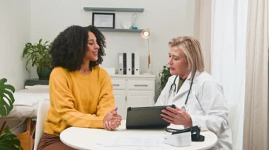 Profesyonel doktor çeşitli hastalara olumlu tıbbi danışmanlık sağlar. Aynı beşliği paylaşıyorlar, iyi haberleri ve başarılı sağlık sonuçlarını kutluyorlar, klinik ortamda güven ve açık iletişimi vurguluyorlar..