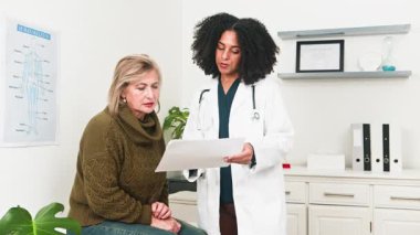 Şefkatli, çeşitli bir doktor, temiz ve çağdaş bir klinikte uzman bir hastaya profesyonel tıbbi danışmanlık hizmeti sunar. Hekim açık açıklamalar ve empatik bakım sunuyor ve ziyaret sırasında hastanın iyiliğini vurguluyor..