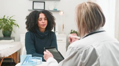 Yetenekli bir doktor, çeşitli kadın hastalara danışarak, sağlık ve boğaz sorunlarını ele alır. Hasta, rahatsızlığını belirterek boynuna işaret eder. Doktor ise, temiz ve profesyonel bir klinik ortamında bir tablet üzerine notlar alır..