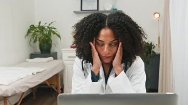 Şaşkına dönmüş kadın doktor, doktorların sağlık hizmetlerinde yorgunluk ve tükenmişlik sorunlarını gösteriyor. Doktor sağlığının ve ruh sağlığının önemini vurgulayarak çevrimiçi konsültasyonlar talep ediyor..