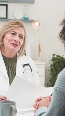 A friendly and experienced female doctor discusses medical results with her young patient during a positive and informative consultation. They are in a modern clinic, focusing on healthcare, treatment, and well-being. Ideal for medical themes.