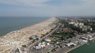 Güneşli bir yaz gününde İtalya 'daki ünlü Rimini Riviera' nın hava manzarası. Bir sürü şemsiyesi ve ikonik dönme dolabı olan kumlu bir sahil.