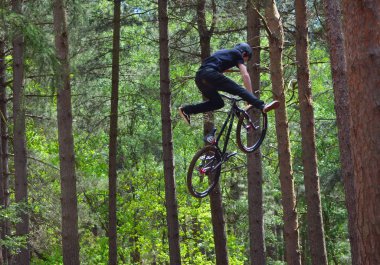 Haynes, Bedfordshire, İngiltere - 14 Mayıs 2017: Freestyle Stunt bisikletçi orta hava çok yüksek ağaçlar arka planda ile. 