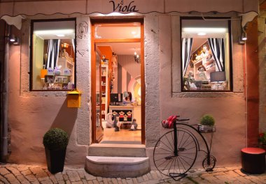 Rovinj, Istria, Hırvatistan - 21 Haziran 2017: Dükkanı açık ışıkları ve Rovinj Hırvatistan eski bisiklet ile gece. 