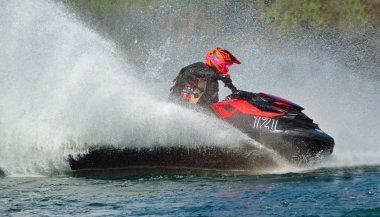 Jet Ski yarışmacısı hızla köşeye sıkışıyor ve çok fazla sprey üretiyor.