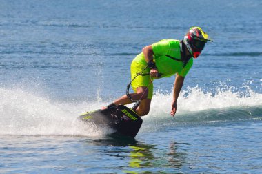 Wyboston, Bedfordshire, İngiltere - 08 Temmuz 2017: Erkek Motosurf rakip alarak köşe hızda sprey bir sürü oluşturma.