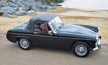 Felixstowe, Suffolk, İngiltere - 07 Mayıs 2017: Sahil mesire deniz arka planda ile klasik siyah Mg Midget araba park.