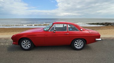 FELIXSTOWE, SUFFOLK, ENGLAND - MAYIS 05, 2019: Deniz kenarına park edilmiş klasik kırmızı Reliant Scimitar.