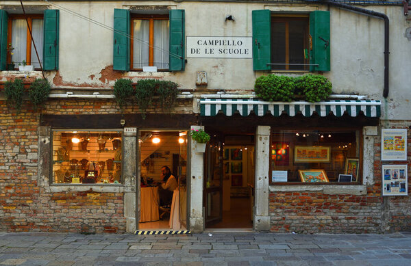 VENICE, ITALY - SEPTEMBER 25, 2017: Old Shop Fronts a Jewellers and an Art Gallery in Venice close to the Jewish Quarter taken in early evening.