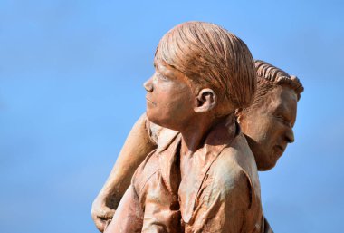  PLAYA BLANCA, LANZAROTE, İspanya - Nisan 04, 2019: Mavi gökyüzü arka planıyla güreşen genç çocukların heykeli.