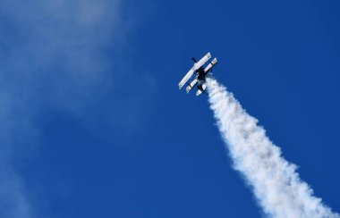 Little Gransden, Cambridgeshire, İngiltere - 25 Ağustos 2019: Pitts Model 12 dumanlı yol ve mavi gökyüzü ile gösteri yapıyor..