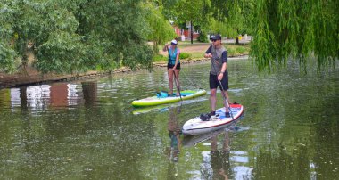 BEDFORD, BEDFORDSHIRE, İngiltere - 26 MAYIS 2020: Genç çift Bedford 'daki Ouse nehrinde kürek çekiyorlar.