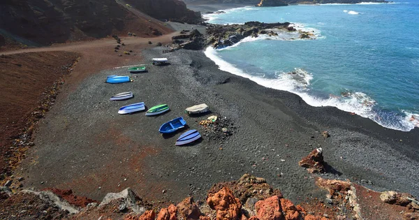 Vulkaniska Kustklippor Och Vågor Golfo Lanzarote Spanien Med Båtar Stranden — Stockfoto