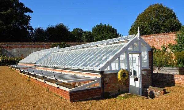 AYLSHAM, NORFOLK, ENGLAND - 21 Eylül 2020: Ağaçlı ve mavi gökyüzü olan geleneksel yeşil evler.