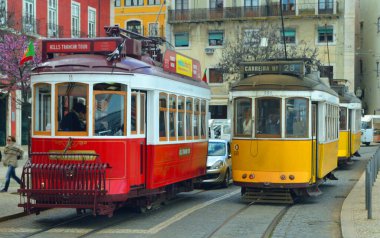 LISBON, PORTUGAL - Mart 02, 2016: Largo das Portas do Sol üzerinde üç geleneksel eski kırmızı ve sarı Lizbon tramvayı trafiği engelliyor.