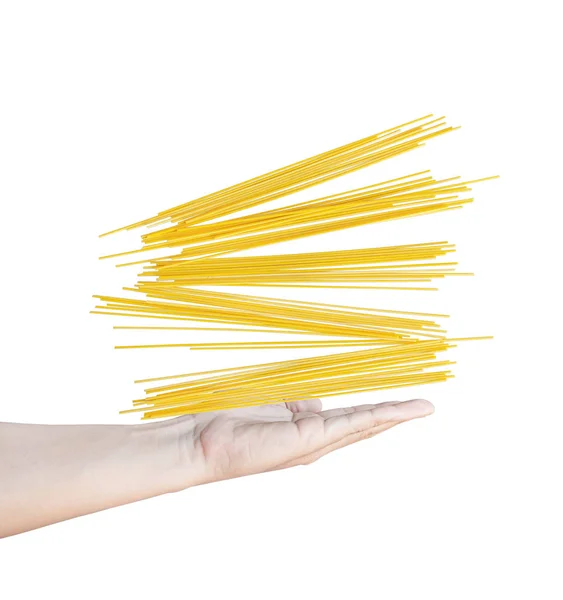 Mão segurando espaguete cru, as mãos estão jogando espaguete para cima . — Fotografia de Stock
