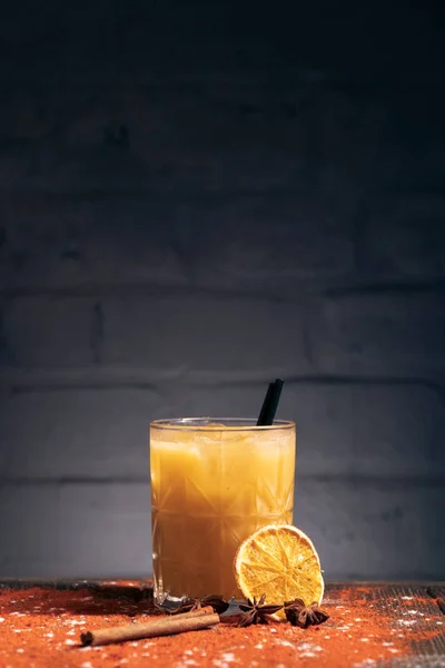 Oranje cocktail met kaneel en stro op baksteen achtergrond; — Stockfoto