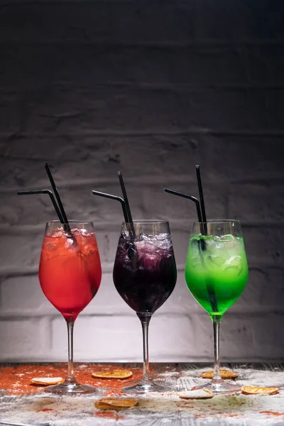 set of colorful alcohol cocktails with straws;