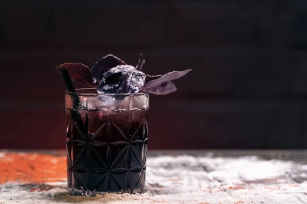 Szklanka z ciemnym koktajlem z jagodami i liściem bazylii; — Zdjęcie stockowe