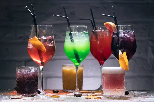 set of colorful alcohol cocktails with straws;