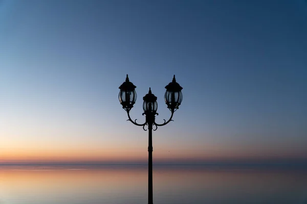 Lámpást a kék naplemente ég és tó — Stock Fotó