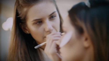 visagist profesyonel kozmetik ve fırçalar ile makyaj yapıyor