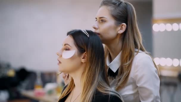 Visagist provádí make-up s profesionální kosmetikou a kartáčky — Stock video